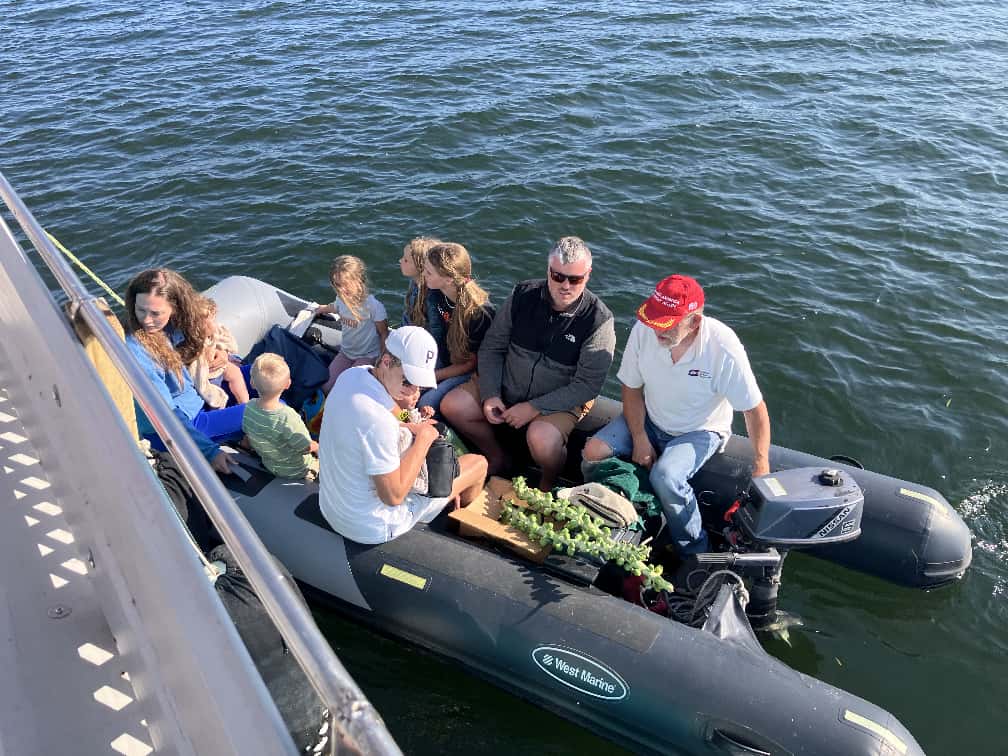 People gathered aboard Deo Gratis on open water